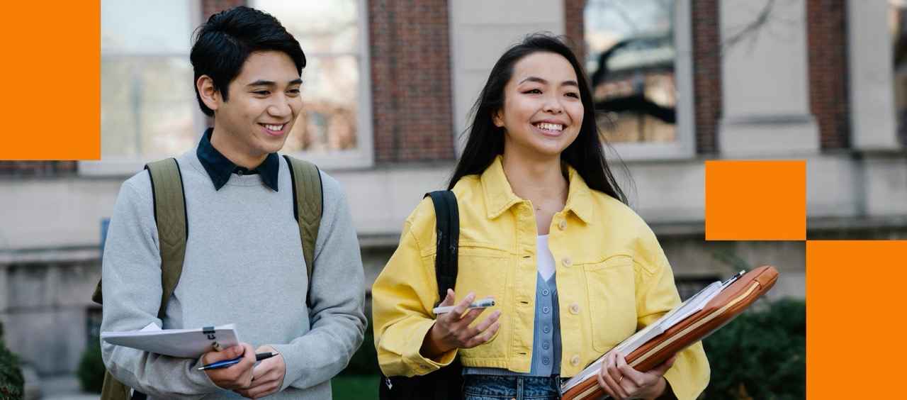Two smiling students with backpacks on campus, representing the Risers community